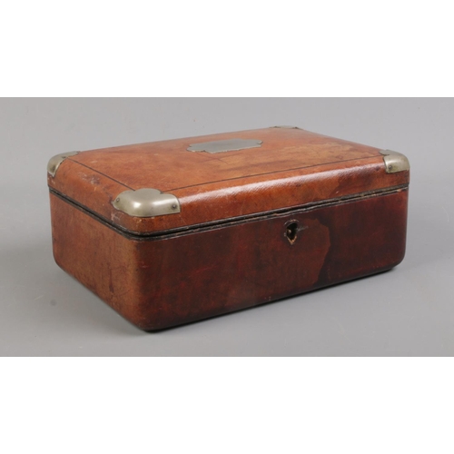 116 - A Victorian brown leather, blue silk and velvet lined dressing case; with white metal mounts and bev... 