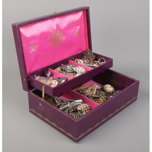 12 - A cantilever jewellery box with contents of costume jewellery. Includes brooches, rings and dress cl... 