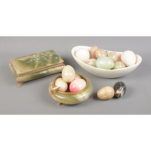 127 - A collection of decorative hardstone eggs along with trinket dish and box.