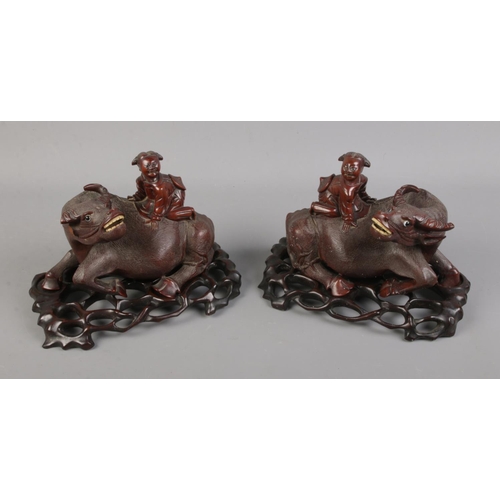 155 - Pair of oriental carvings of a boy on buffalo, base 22 cm wide.