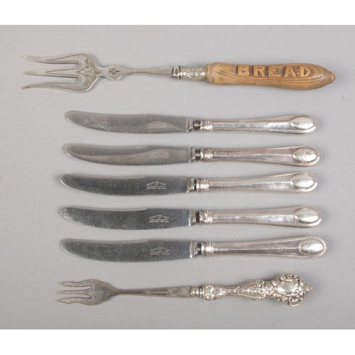 161 - A collection of silver handled cutlery, together with a carved wooden handled bread fork. The majori... 