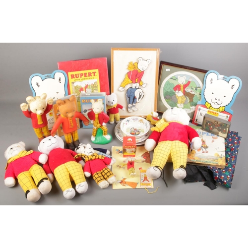 204 - A box of Rupert Bear collectables. Includes Wedgwood ceramics, 1969 Bendy figure, soft toys, waistco... 