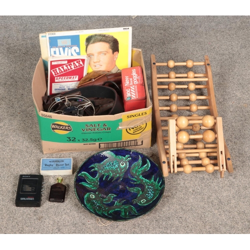 216 - A box of miscellaneous to include four Elvis Presley records, carved African figures, Halifax Speedw... 