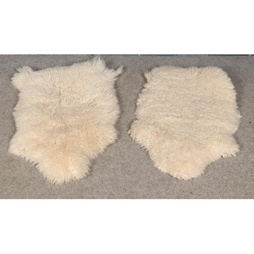 255 - Two small sheep skin wool rugs. (100cm x 65cm)