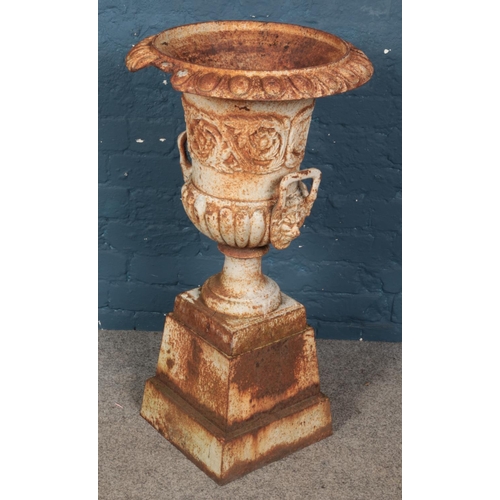 260 - A large cast iron garden urn. With floral decoration and lion mask handles. (89cm x 47cm)