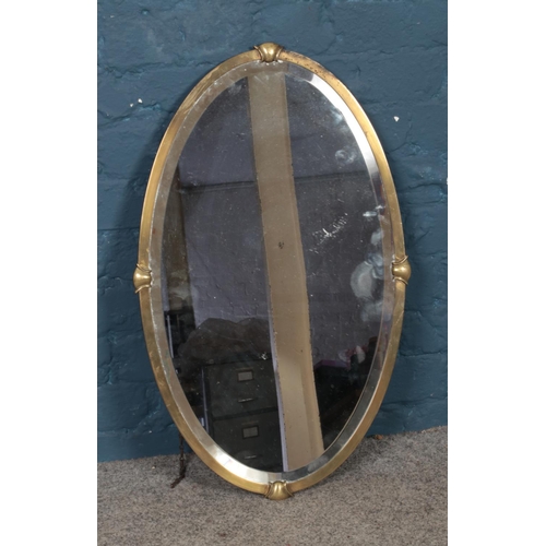 358 - A brass framed elliptical bevel edge mirror. Approx. dimensions 44.5cm x 72cm.