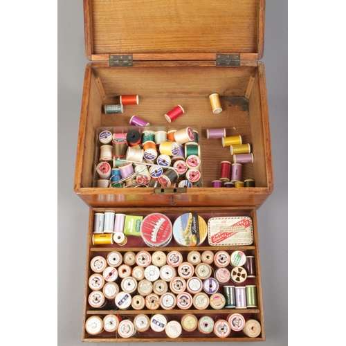 66 - An oak cased sewing box with contents of a large quantity of sewing threads.