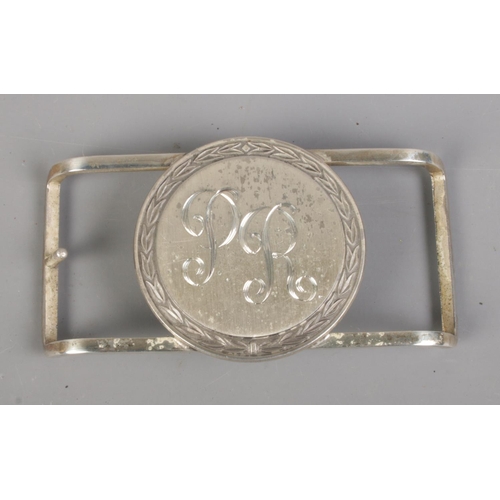 421 - A Jostens sterling silver belt buckle featuring PR engraved initials. Total weight 87.5g.