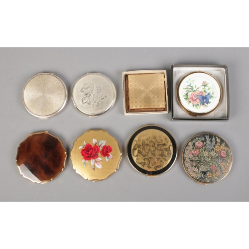 76 - Eight Stratton compacts including butterfly and floral examples.