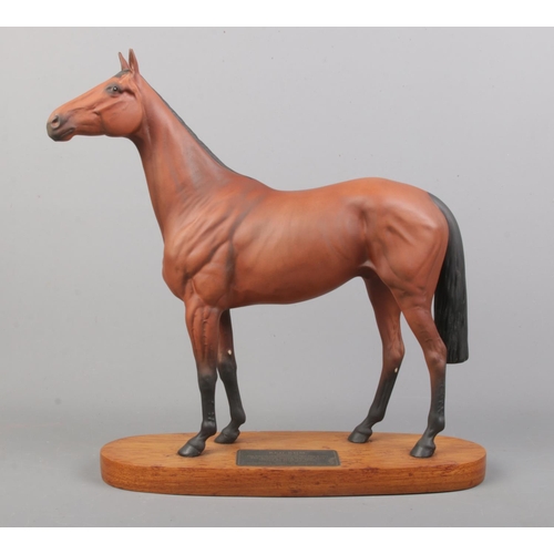 453 - A connoisseur model by Beswick of Red Rum, raised on wooden plinth. Height: 32cm.