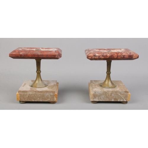 86 - Two marble stands with turned central metal stems, raised on four small turned feet.