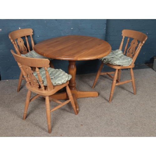 468 - A modern drop-leaf dining table and three chairs.