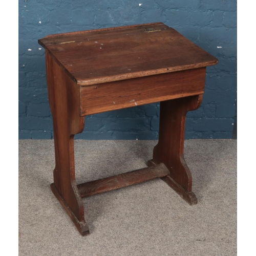 471 - An oak school desk featuring fitted inkwell and hinged compartment. Approx. dimensions 61cm x 45cm x... 