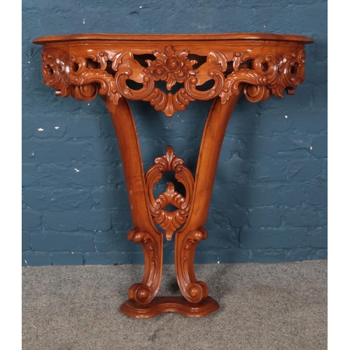 474 - A carved hardwood console table featuring floral scroll decoration. Approx. dimensions 84cm x 28cm x... 