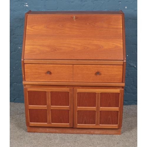 476 - A mid-century modern Parker Knoll teak bureau with single drawer and pair cupboard doors, on plinth ... 