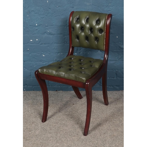 480 - A mahogany and leather deep button chair.