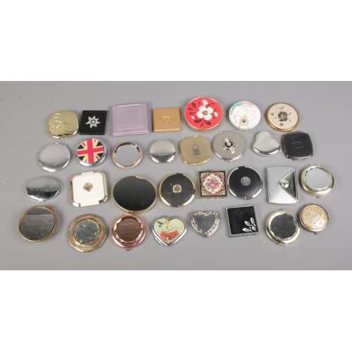 96 - A large collection of assorted compacts to include floral, Nottingham Forest, embroidered examples, ... 