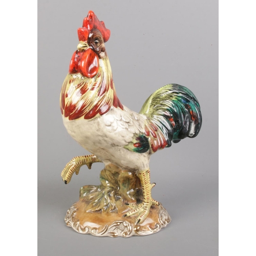 99 - An Italian ceramic cockerel with gilt detailing to the base. 29cm high.