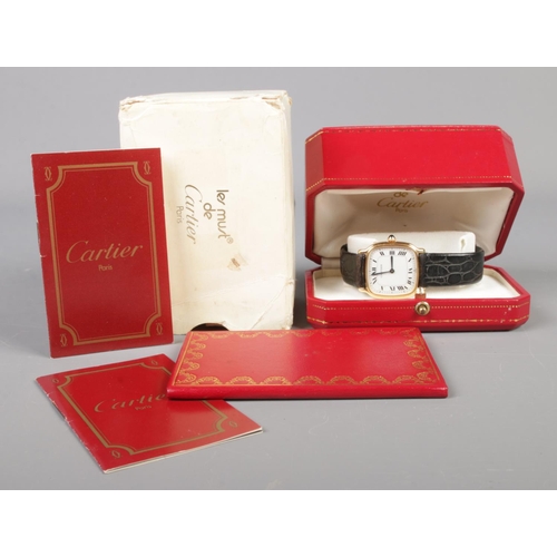 102 - An 18ct gold Cartier manual wristwatch. Having Roman numeral markers. With leather strap and 18ct go... 