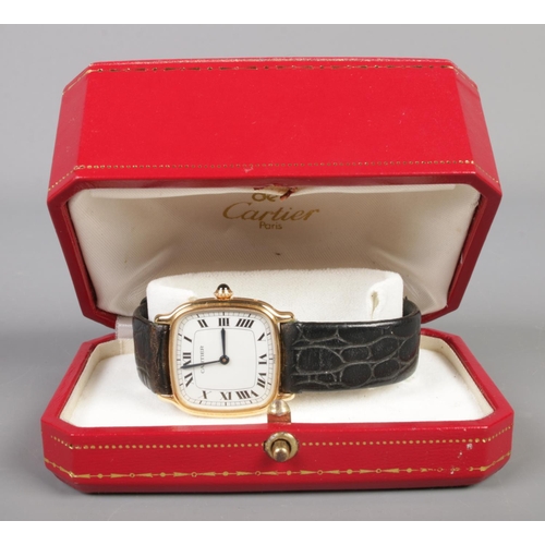 102 - An 18ct gold Cartier manual wristwatch. Having Roman numeral markers. With leather strap and 18ct go... 