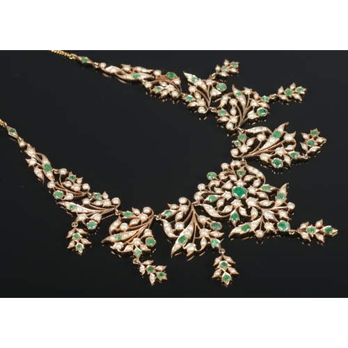 103 - A gold, emerald and seed pearl necklace of bib form, having reticulated sections. Tests from 14ct to... 