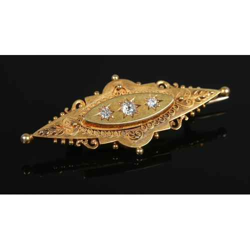 104 - A Victorian 15ct gold and three stone diamond brooch. Having old cut diamonds and locket back. 5cm l... 