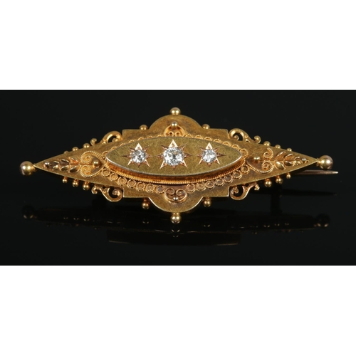 104 - A Victorian 15ct gold and three stone diamond brooch. Having old cut diamonds and locket back. 5cm l... 