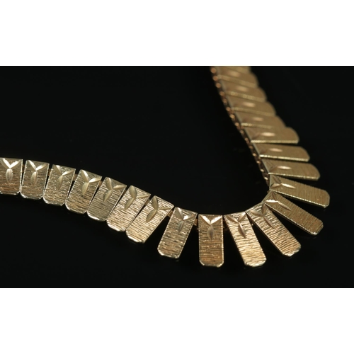 105 - A 9ct gold graduated necklace. Each panel with textured and bright cut engraving. Import mark for Bi... 