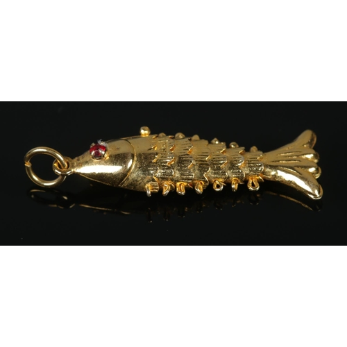 110 - Two yellow metal articulated fish pendants, both set with red coloured stone eyes. Length 3cm. 1.79g... 