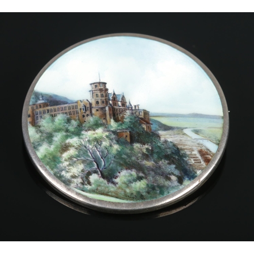 111 - A continental silver and enamel brooch decorated with a landscape scene and castle. 5cm diameter. St... 