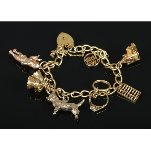 114 - A 9ct gold charm bracelet with 9ct gold and 14ct gold charms. 32.07g.