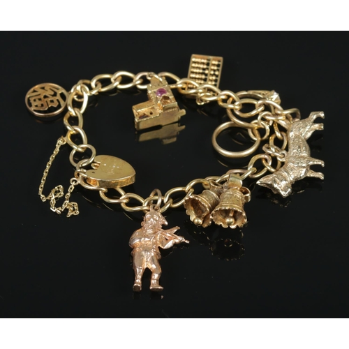 114 - A 9ct gold charm bracelet with 9ct gold and 14ct gold charms. 32.07g.