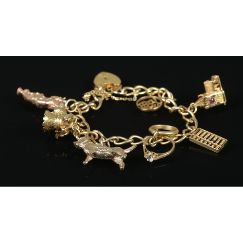 114 - A 9ct gold charm bracelet with 9ct gold and 14ct gold charms. 32.07g.