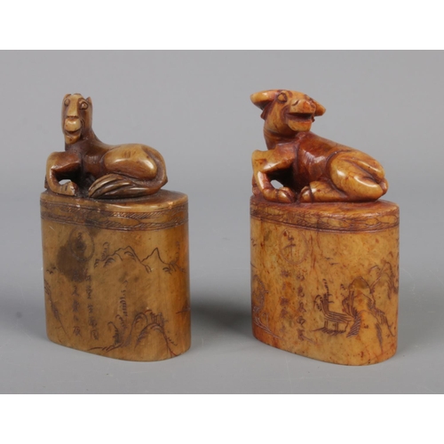 12 - Two 19th century Chinese carved soapstone seals, both surmounted with animals, one a water buffalo, ... 