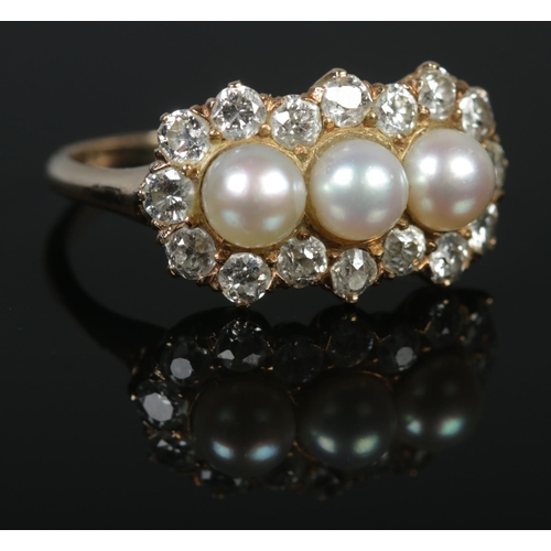 126 - A yellow gold pearl and diamond cluster ring. Having three central pearls with 16 stone diamond bord... 