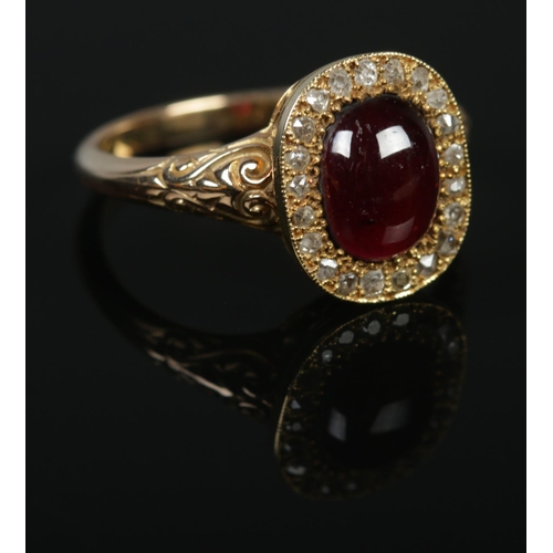 136 - A gold, garnet and diamond ring with scrolled shoulders. Size P 1/2. 4.46g. Tests as 9ct gold.