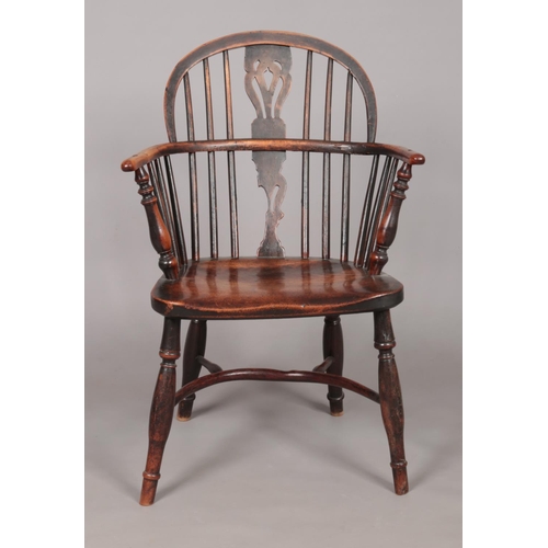 168 - A 19th century ash/elm and yew wood Windsor arm chair with crinoline stretcher. Height of back 86cm,... 