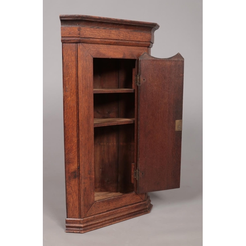 174 - A Georgian oak corner cupboard with shell patera inlaid door. Height 88.5cm, Depth from back corner ... 