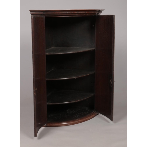 175 - A large Georgian oak bow front corner cupboard with crossbanded doors. With key. Height 96cm, Depth ... 