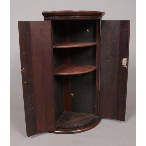 176 - A small Georgian mahogany corner cupboard. Height 68cm, Depth from back corner to front centre 30.5c... 