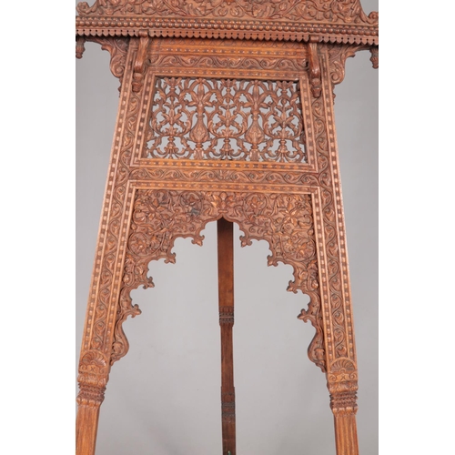 179 - A large easel with extensively carved floral decoration. Height 180cm.