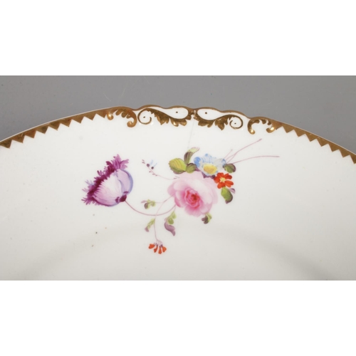 20 - A Rockingham plate decorated with hand painted flowers and gilt border. Red griffin mark C1826-1830.... 