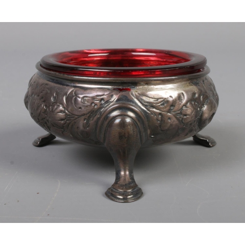 51 - A pair of George III silver salts with red glass liners and raised on three scrolled feet. Assayed L... 