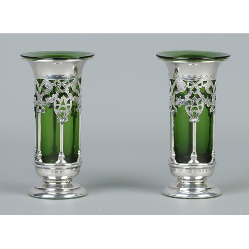 55 - A pair of Edwardian pierced silver vases with green glass liners. Weighted bases. Assayed Birmingham... 