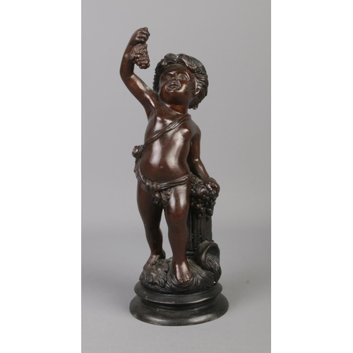 62 - A bronze sculpture modelled as a cherub standing beside a grape hod and holding a bunch of grapes. 2... 