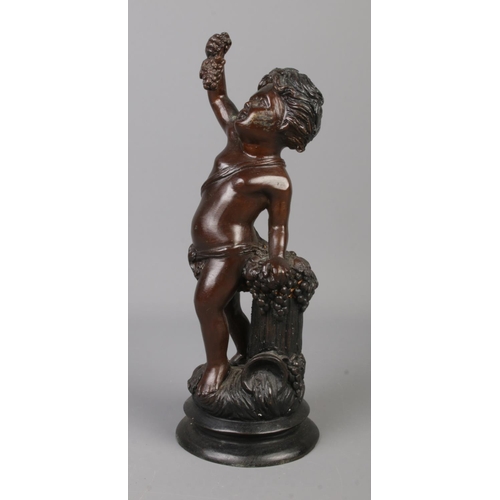 62 - A bronze sculpture modelled as a cherub standing beside a grape hod and holding a bunch of grapes. 2... 