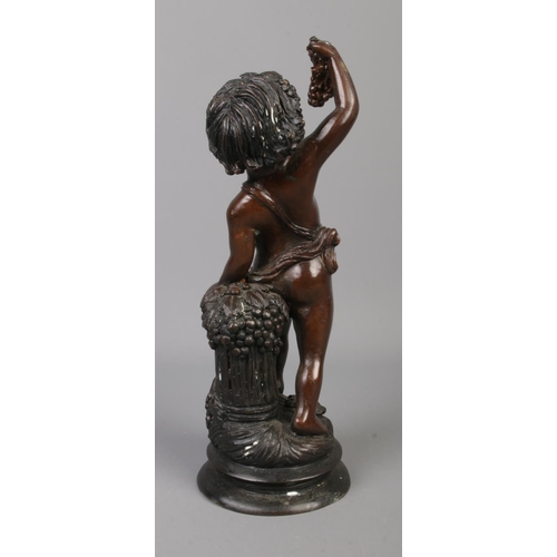 62 - A bronze sculpture modelled as a cherub standing beside a grape hod and holding a bunch of grapes. 2... 