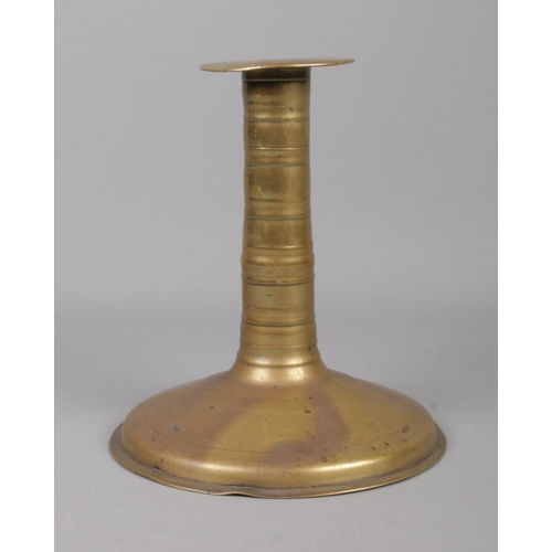 64 - A 17th century brass candlestick with trumpet base and bobbin stem. Height 19.5cm.