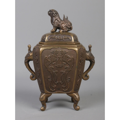 7 - A Chinese bronze censer with cover surmounted by a Foo dog. Having twin elephant mask handles and dr... 