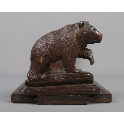 77 - A Black Forest wooden book stand with carved bears to each end.